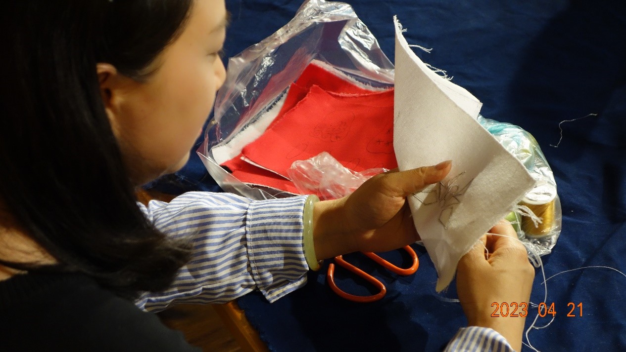 Provincial level inheritor Ms. Wu Yongzhi demonstrating the crafting of a butterfly pattern embroidery